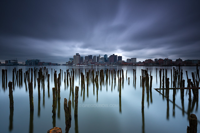 Downtown Boston Skyline over Sea of Decayed Pilings under Stormy Sky, East Boston Massachusetts