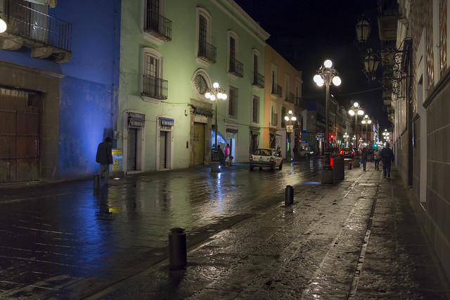 Lights reflected on puddled streets at night in Puebla, Mexico