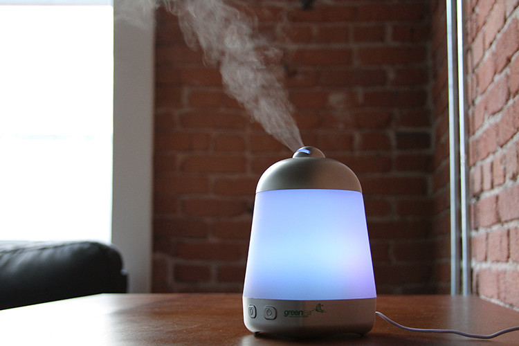 neon essential oil diffuser misting on table
