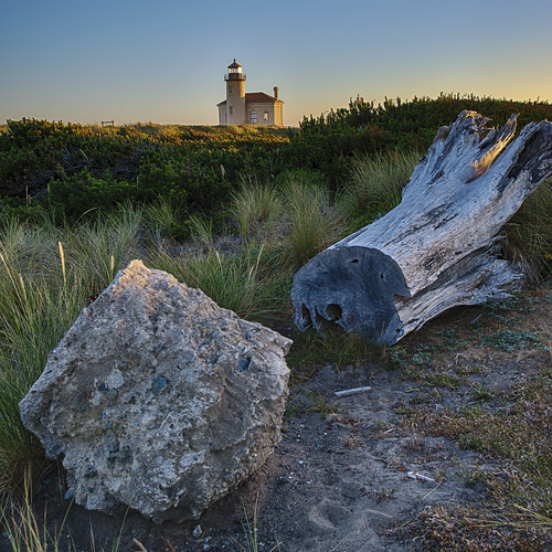 sunset lighthouse boulder treestump coquilleriverlighthouse lighthouseatsunset
