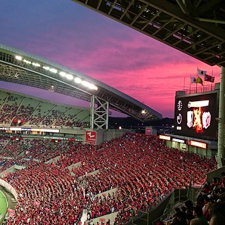 Pink sky behind Urawa Reds supporters.