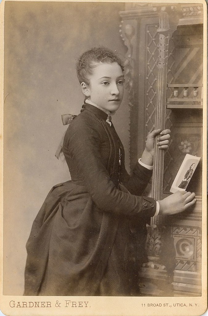 A young girl holds a photo of herself cabinet photo