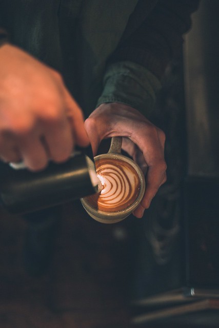 man pouring latte art to cup filled with coffee - Credit to https://myfriendscoffee.com/