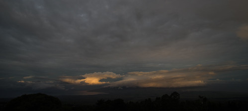 Sunrise by ArneKaiser, Sun rays are peeking under a cloud bank and illuminating a faraway storm cloud during an early morni