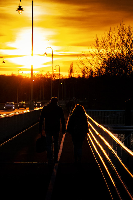 Couple walking in the sunset light on the Wilhelmina bridge in Deventer Overijssel. I could hear the Mansplaining for a distance. Always fun.
