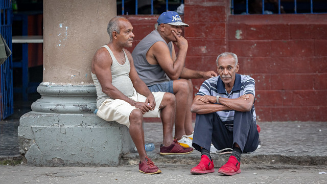 Three Men Sitting by the Street