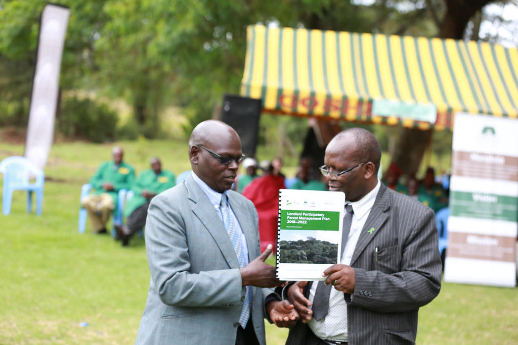 County government of Kericho representative receiving a copy of the Participatory Forest Management Plan (PFMP).