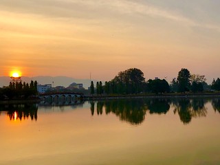 The beautiful lake with sunrise and dramatic sky - Taksin Maharat Memorial Park in Chanthaburi, Thailand.