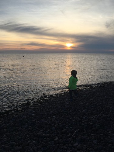 The kid and the sunset, Eagle River. by chaddm, Throwing rocks, of course.
