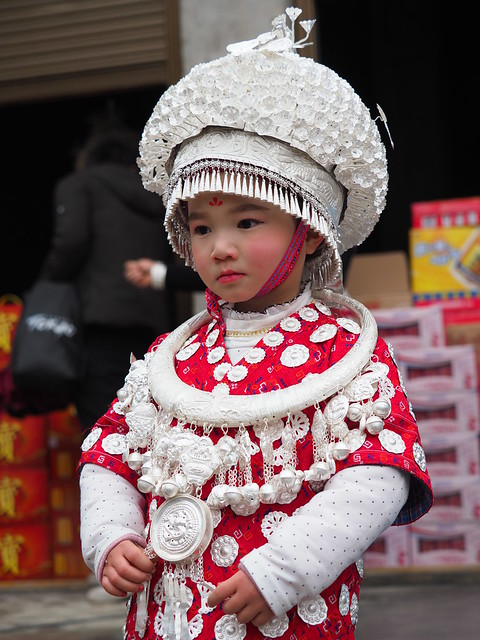 Gulong style Miao kid wearing the traditional headdress and necklaces