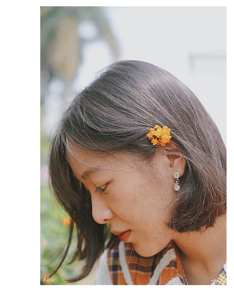 Little girl with short hair and flower. | {