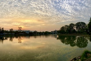 The beautiful lake with sunrise and dramatic sky - Taksin Maharat Memorial Park in Chanthaburi, Thailand.
