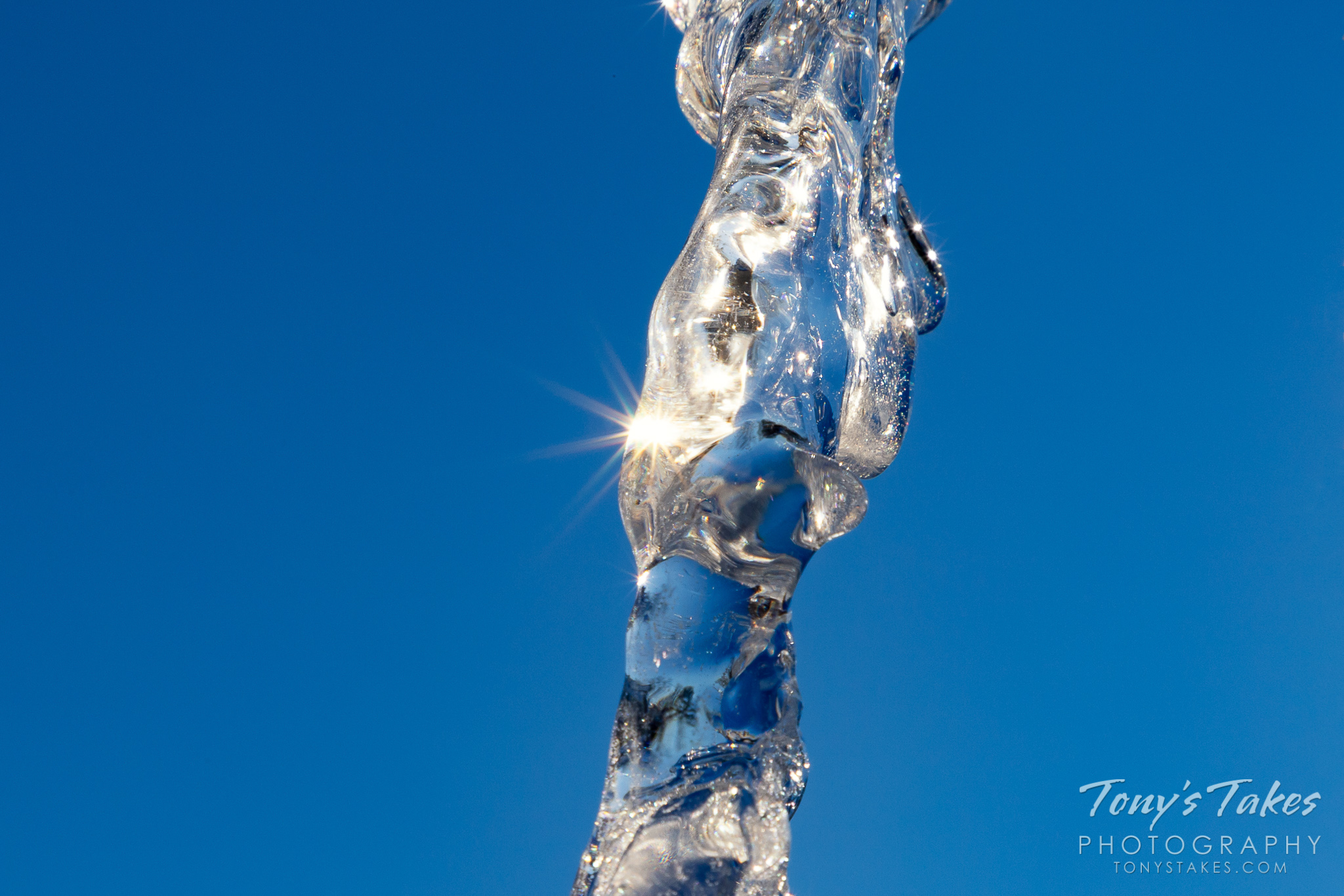 Icicles shine against a deep blue sky in Colorado. (© Tony’s Takes)