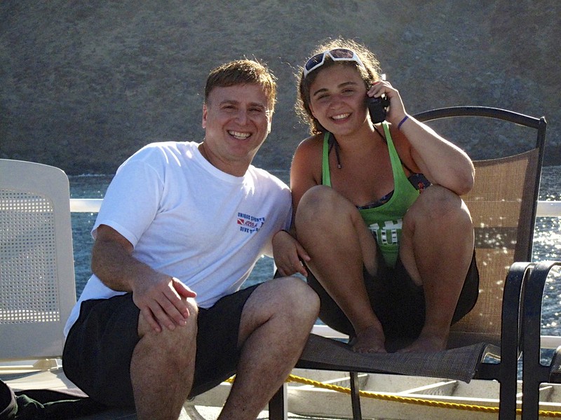 Roger Muller and his cute daughter Taylor on top deck of Nautulis Explorer Guadalupe Island in background - Version 2