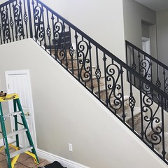 Interior railing fabricated with 1 ¼” x ⅜” flat bar forged scrolls and baskets