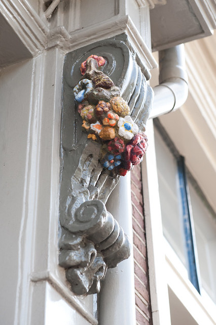 Huize de Moriaan, detailfoto van een sculptuur van een bloementros aan de gevel op straatniveau. Foto: Anna van Kooij.