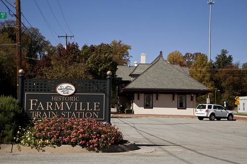 Sign of Historic Farmville Train Station with blooming flowers underneath
