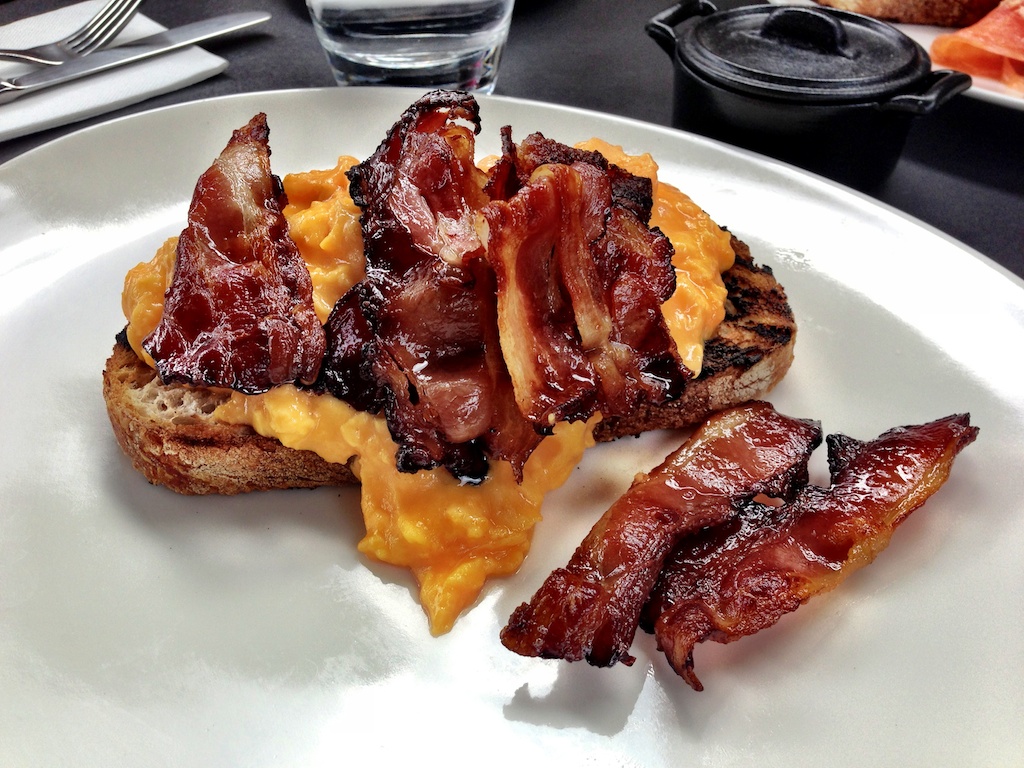 Scrambled eggs on toast with bacon at Speakeasy