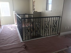 Interior railing fabricated with 1 ¼” x ⅜” flat bar forged scrolls and baskets