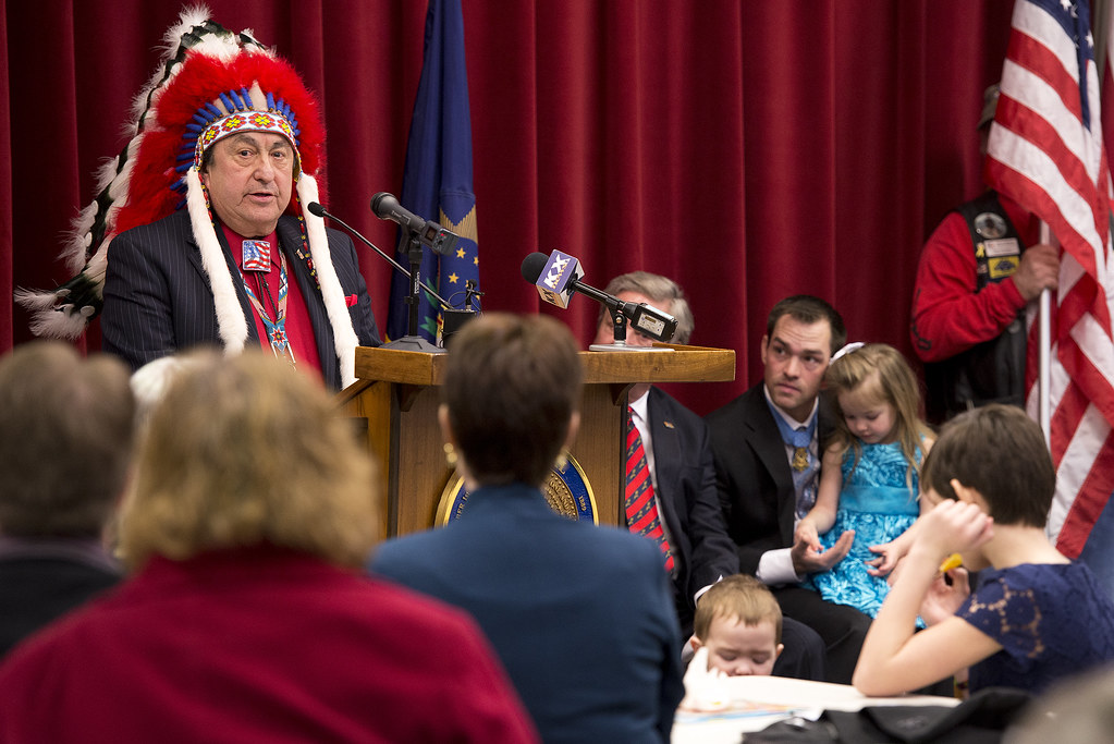 North Dakota State Senator Richard Marcellais, a Native American, presents Medal of Honor recipient Clinton L. Romesha with an eagle statue