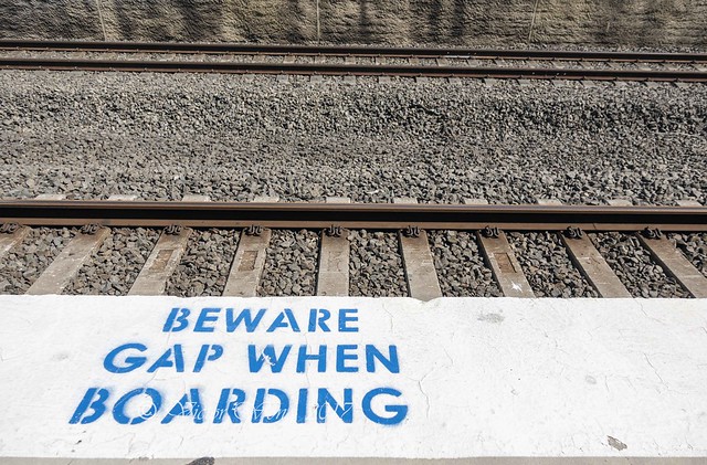Gap warning sign stencil printed between railway platform and track
