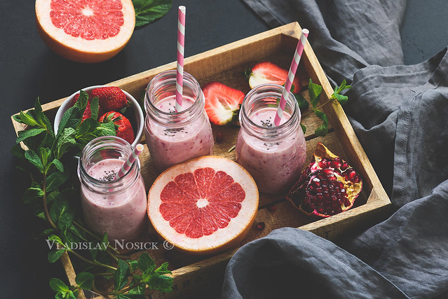 Pink fruit smoothies in bottle. Grapefruit, pomegranate and strawberry smoothies