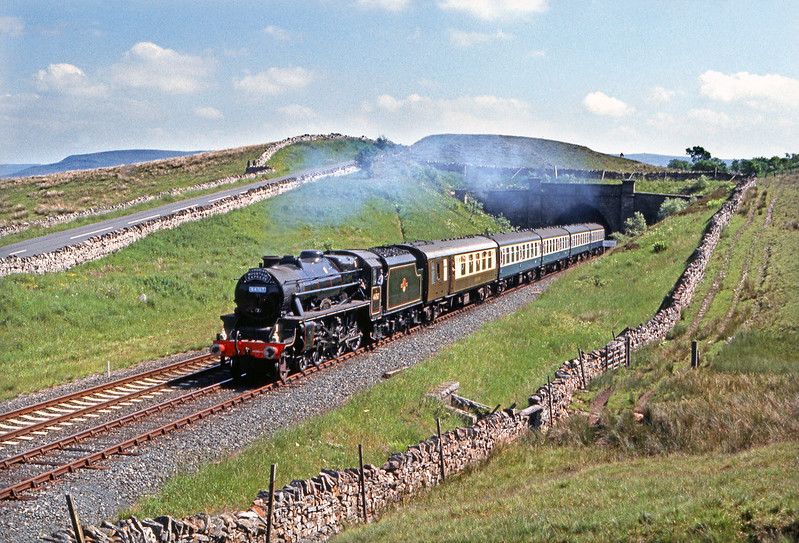 High summer on the S&C as Class 5 44767, 'George Stephenson' emerges from Shotlock Hill Tunnel with a northbound Cumbrian Mountain Pullman.

Pentax Spotmatic. E200.