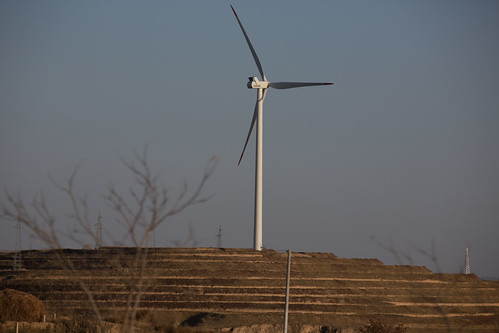 Using Microfinance to Escape Poverty by D J Clark, A wind turbine at sunset. More than 2.5 million people, 41 percent of Ningxia’s population, are livi