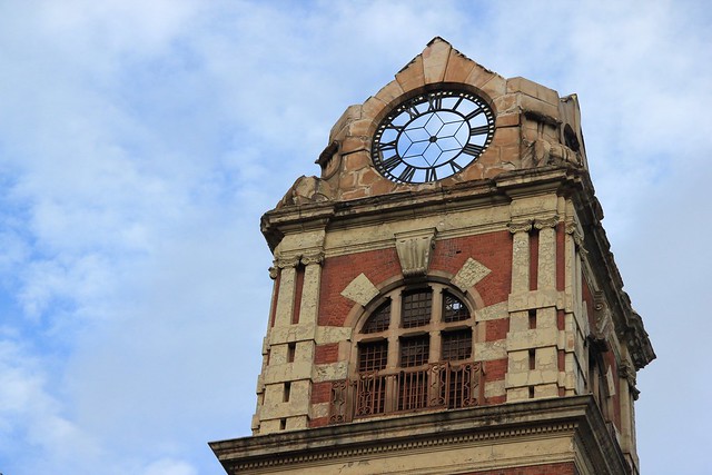 A faceless clock and a clockless face - Face of a dilapidated tower with space for but no clock. The clock in-turn has no face. Johannesburg, South Africa, 2012.