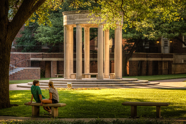 A couple enjoys the beauty of the afternoon light in the Law Quad at SMU.