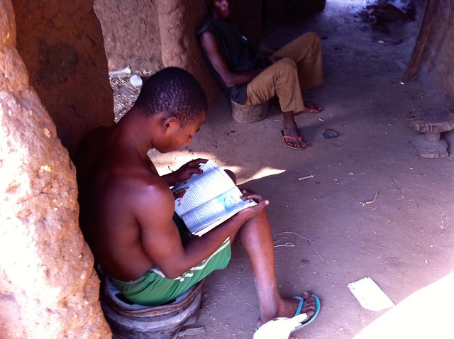Igbira farm boy reading a book in red mud hut, Kogi, Nigeria. #JujuFilms