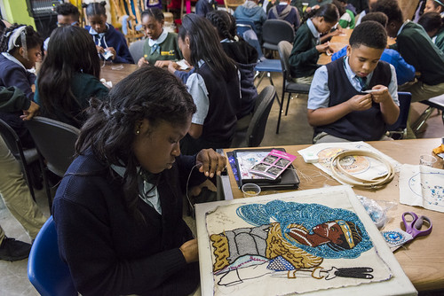Big Queen Regine works on a large piece while classmates help with the smaller patches on November 16, 2017. Photo by rhrphoto.com.