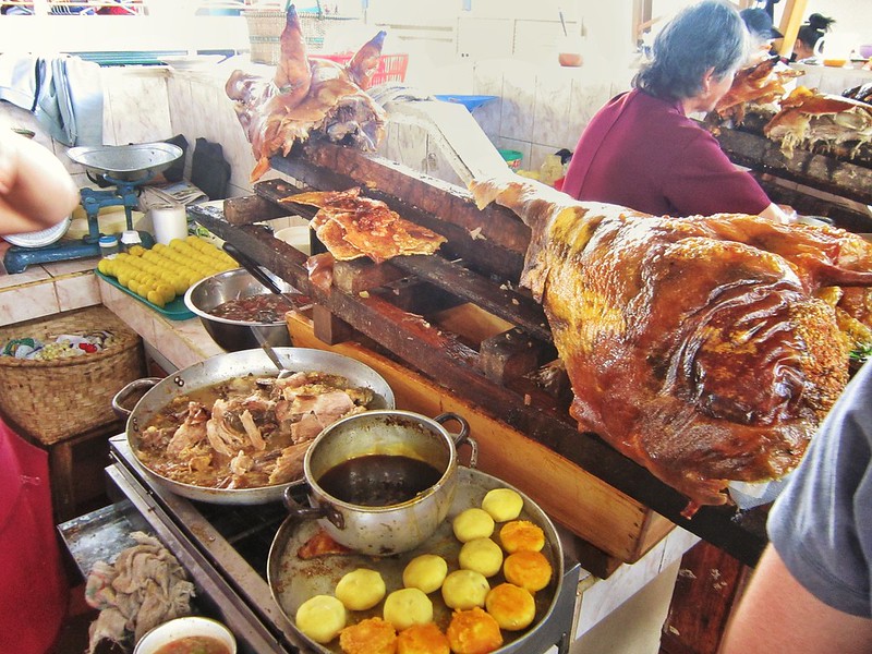 A roast pig on a spit in an Ecuador market