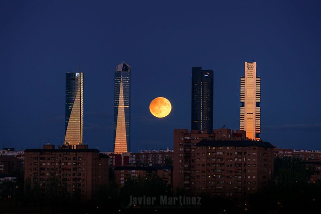 Luna llena con eclipse penumbral entre las Cuatro torres de Madrid