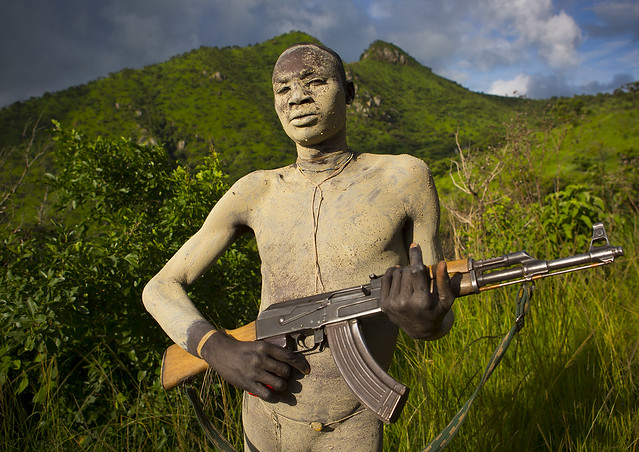 Suri Tribe Warrior With Body Paintings Posing With A Kalashnikov, Omo Valley, Ethiopia
