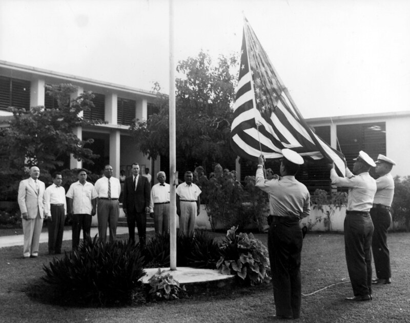 Governor Richard Barrett Lowe, Governor of Guam from 1956 – 1959, shown here at a raising of the flag at the Guam Congress Building. He worked well with the Guam Legislature, unlike his predecessor Governor Ford Elvidge, and  was determined to remain aloof from local politics. Guam Police official photograph, courtesy of the Micronesian Area Research Center (MARC).