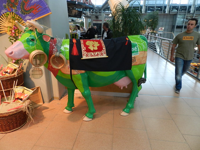 Green Cow with steamer ear-rings let on the loose in Hamburg Airport Terminal!