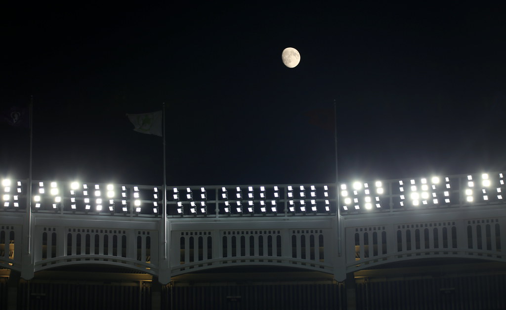The Moon is in a Waxing Gibbous phase over the Yankee Stadium facade.