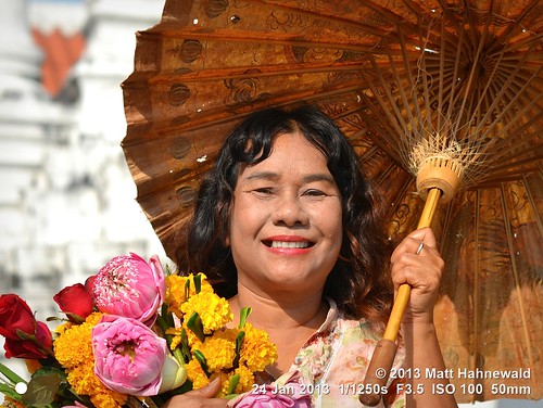 temple parasol bokeh cultural character female adult consent portrait posing travel tourism teeth depthoffield smiling hair devotee beautiful primelens brown closeup street eyes traditional asia matthahnewaldphotography face facingtheworld buddhism horizontal hand nakhonsithammarat nikond3100 outdoor southeastasia thai thailand flower 50mm expression headshot nikkorafs50mmf18g fullfaceview clarity 4x3ratio 1200x900pixels resized lookingatcamera colourful colour person