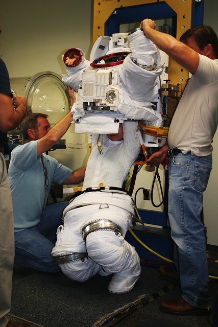 Sam Cristoforetti climbs into a spacesuit at JSC