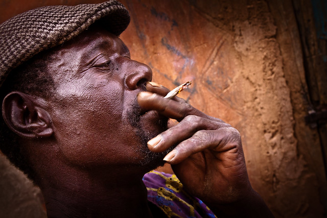 Kasssena man smoking traditional tobacco. Tiebele, Burkina Faso