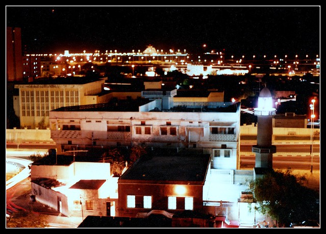 Night view of a mosque in Doha, Qatar. In the distance we see the West Bay area and the landmark Sheraton Hotel ( not standing so alone today though ) - circa 1983.