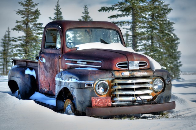 Rusty old Mercury truck in snow.