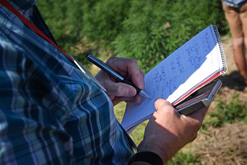 Extension agent takes notes during a tour of a Broadway Hemp farm.