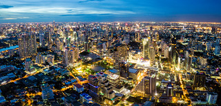 Aerial view of Bangkok skyline and skyscraper on Sukhumvit center of business in capital. Panorama of modern city and BTS skytrain with Benjakiti park on Asoke junction in Bangkok Thailand at night