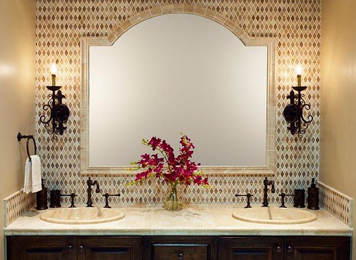 Travertine tile design with chair rail framed mirror