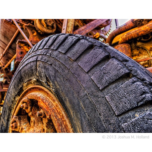 An old beat up worn out tire on old rusty mining equipment… | Flickr