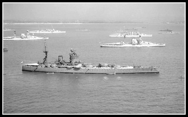 HMS RODNEY off Spithead for the 1937 Fleet Review. Anchored in the background are two Queen Elizabeth Class battleships and two cruisers of the London Class.