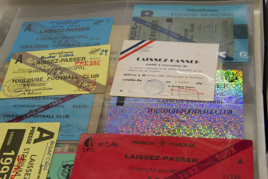 A collection of football tickets and postcard invitations in a clear archival sleeve.