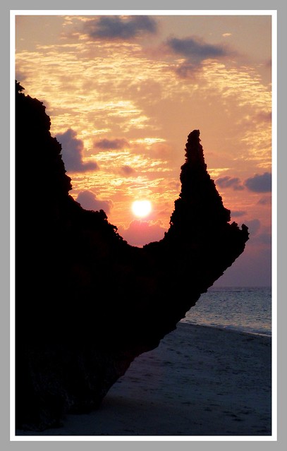 SUNSET THROUGH THE HORN OF THE RINOCEROS ROCK at SESOKO BEACH